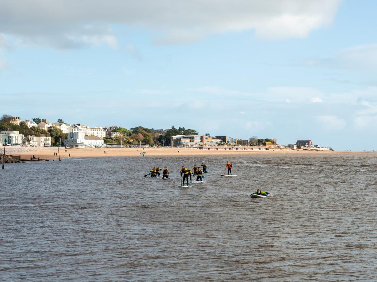 A group of people on paddleboards with Exmouth beach in the background
